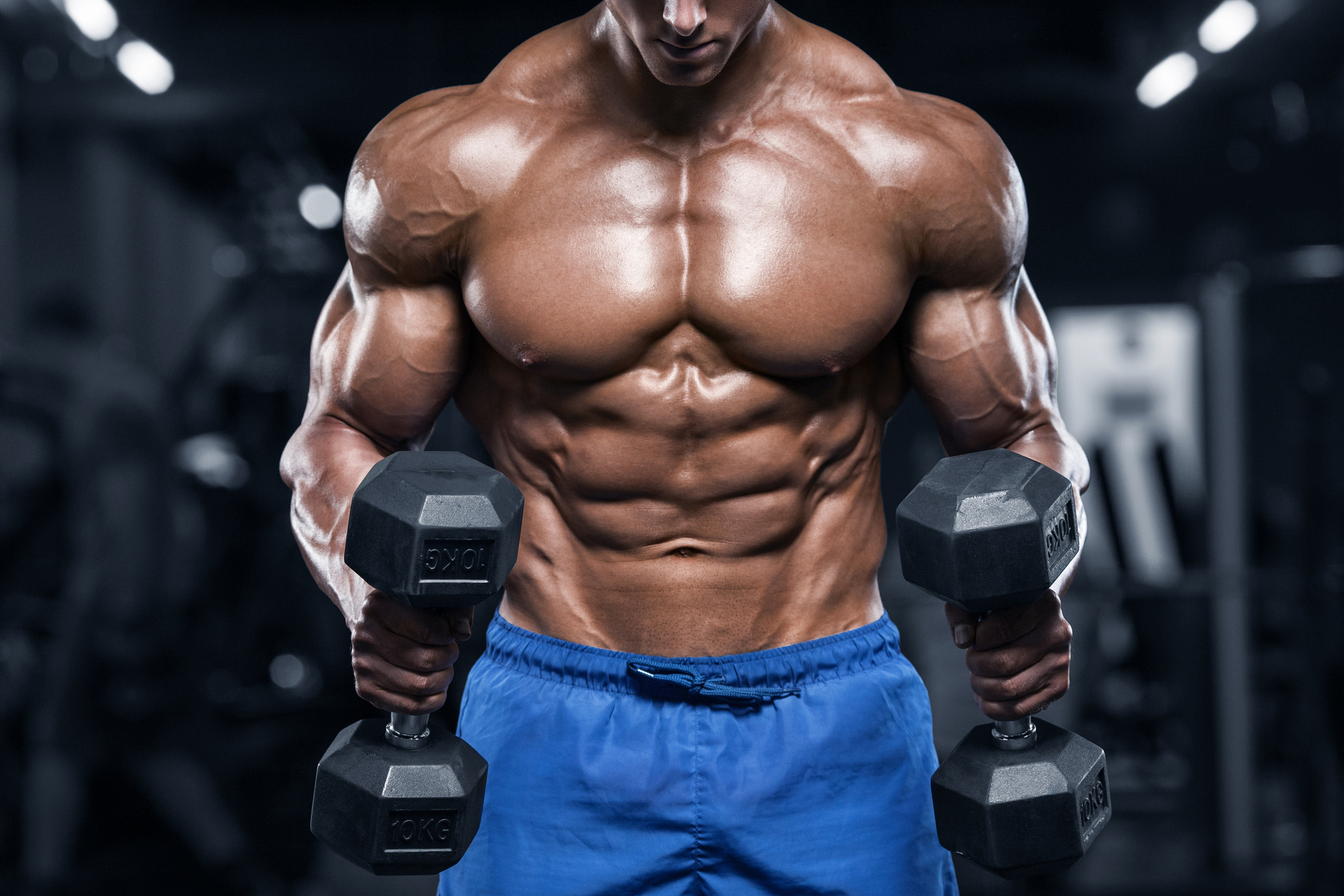 Muscular man working out in gym, strong male torso abs